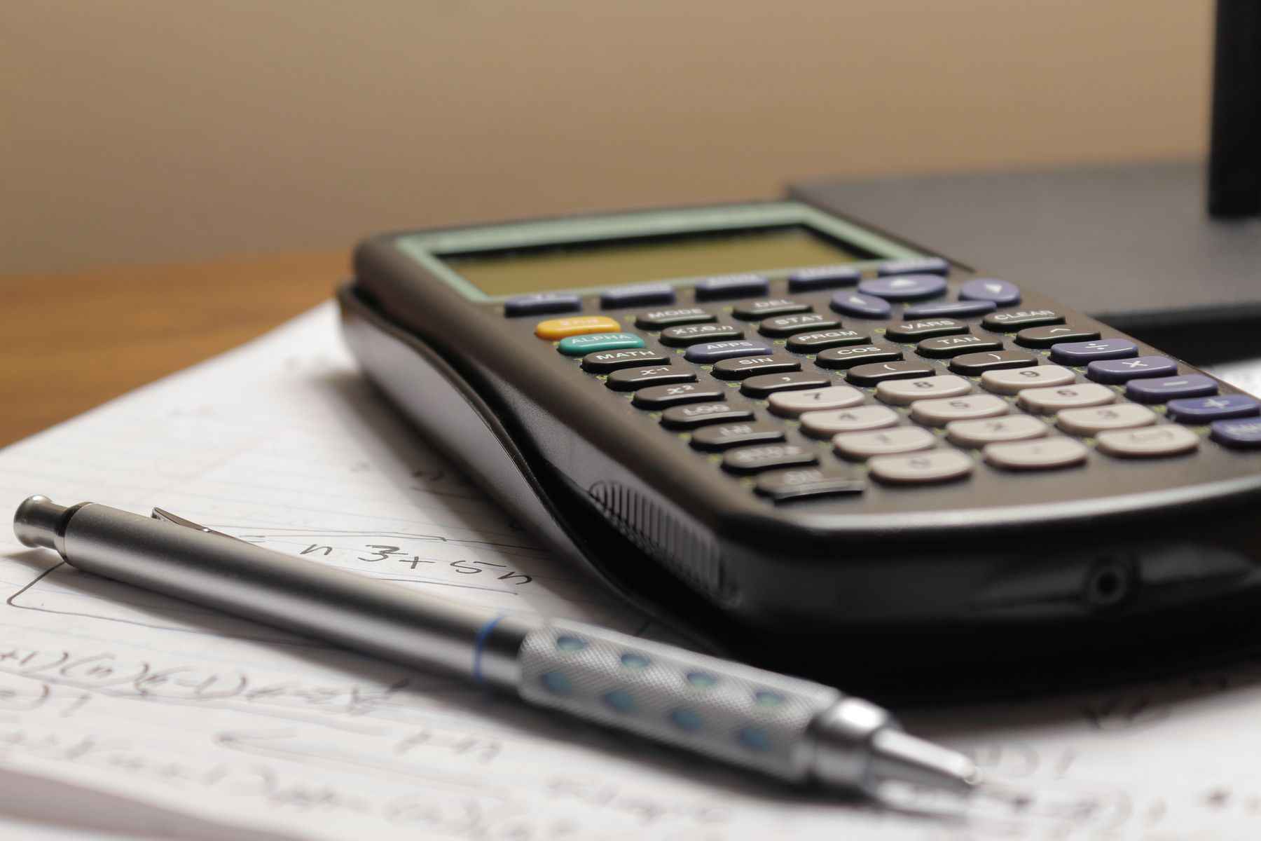 Calculator de birou și creion pe o foaie cu notițe