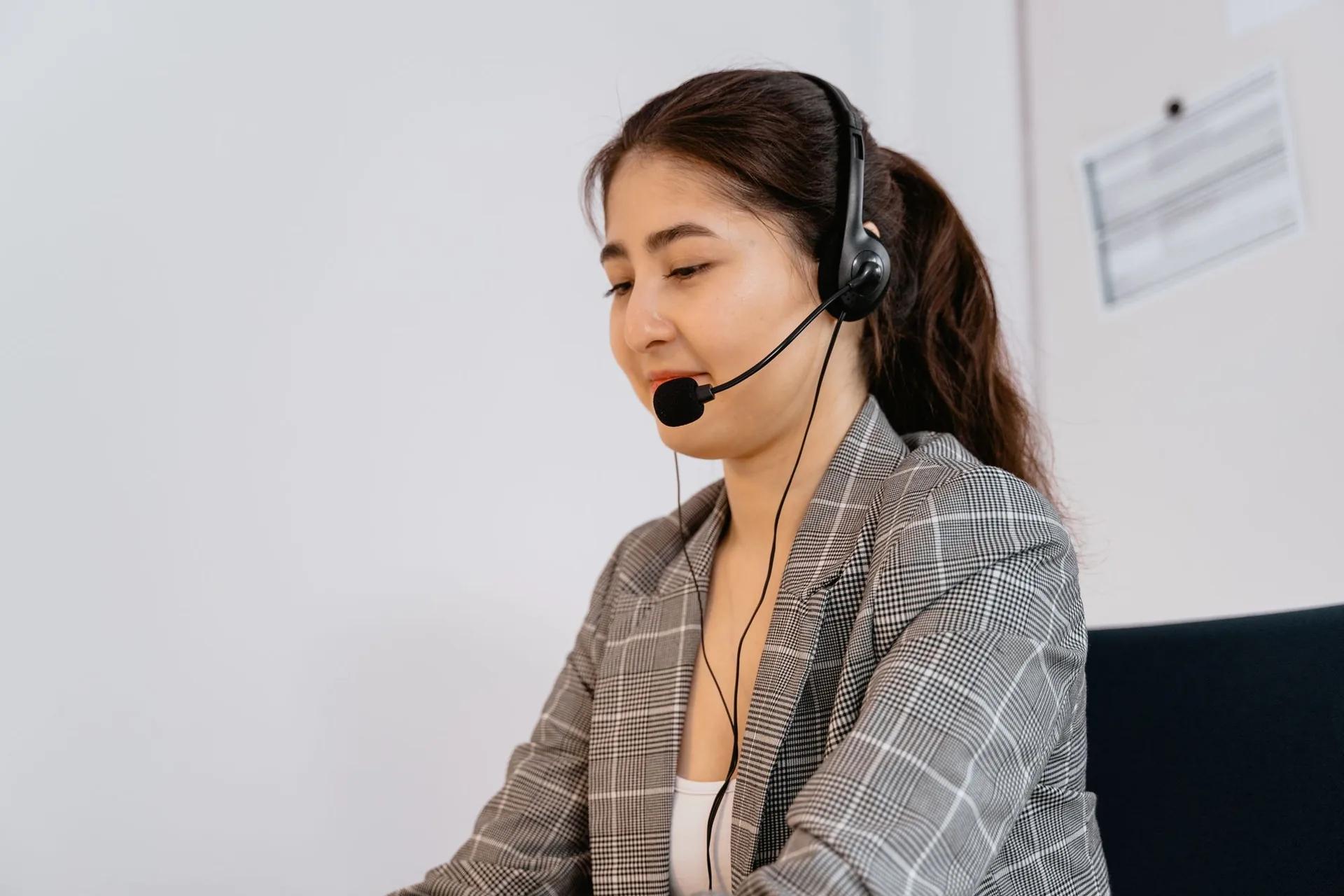 Colegă de la suportul tehnic HostON, cu cască, răspunzând unui client