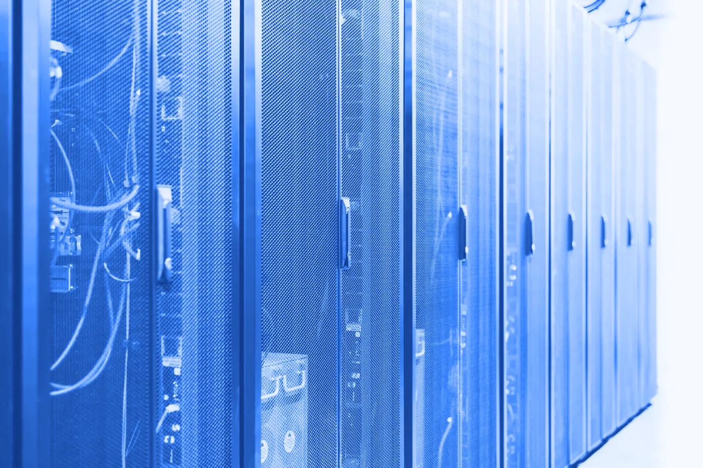 Sală de servere cu rânduri de rack-uri, în lumină albastră