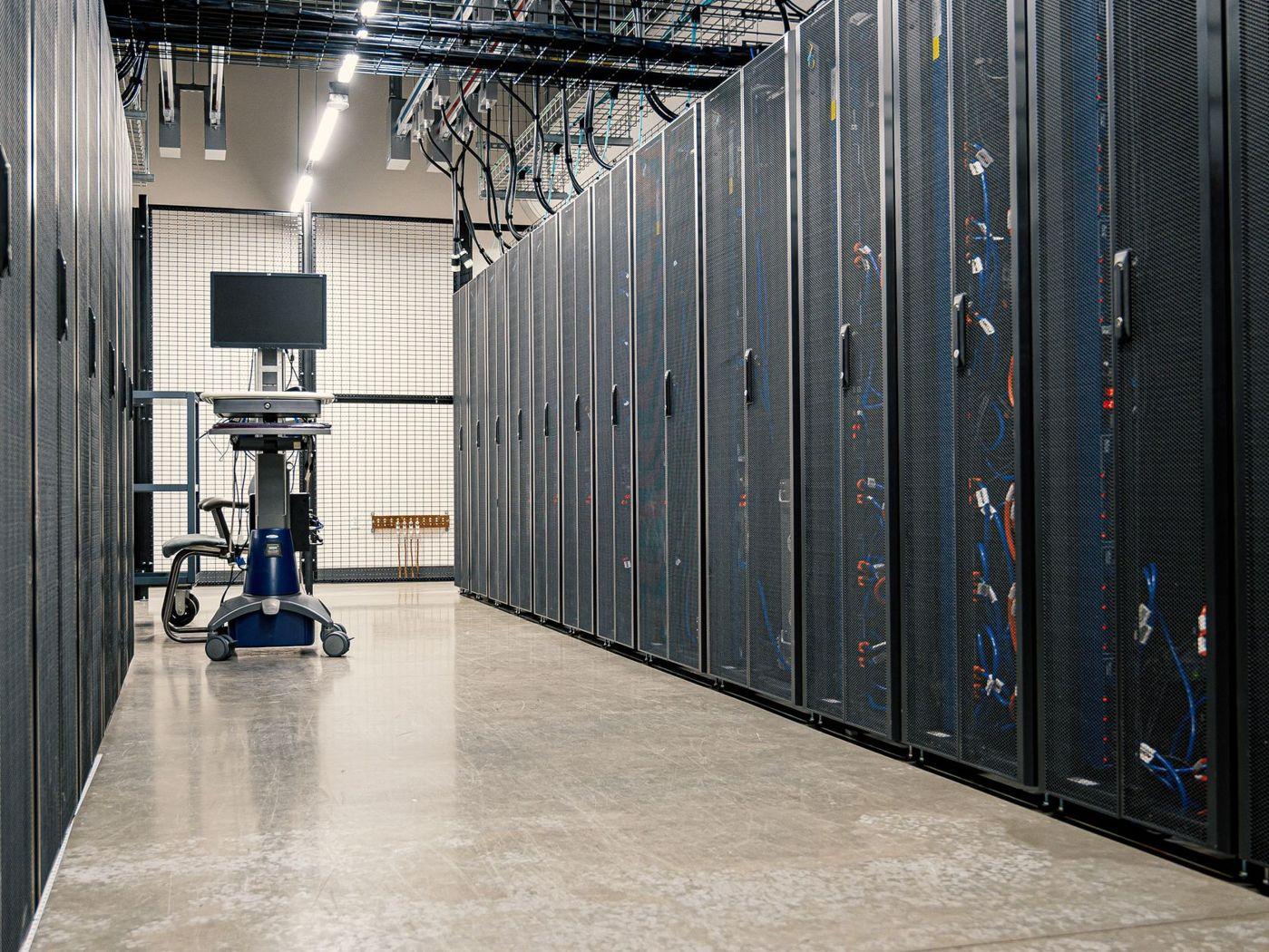 Culoar într-un data center, cu dulapuri de servere de ambele părți